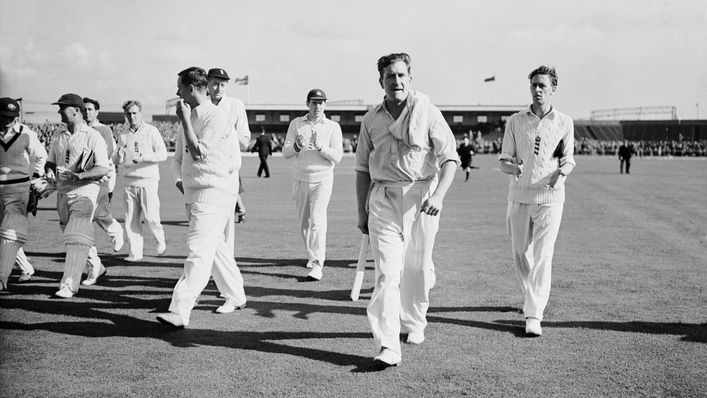 Jim Laker walks off the pitch after taking 19 of the 20 Aussie wickets to fall at Old Trafford