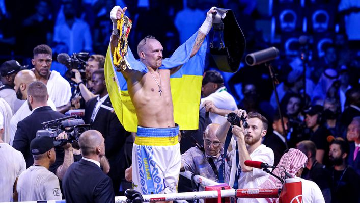 Oleksandr Usyk celebrates after retaining his titles and adding the Ring belt to his collection