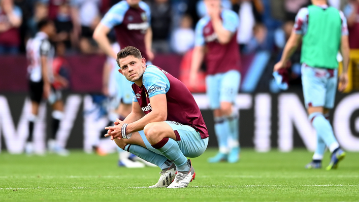 James Tarkowski crouches down in disappointment following Burnley's relegation