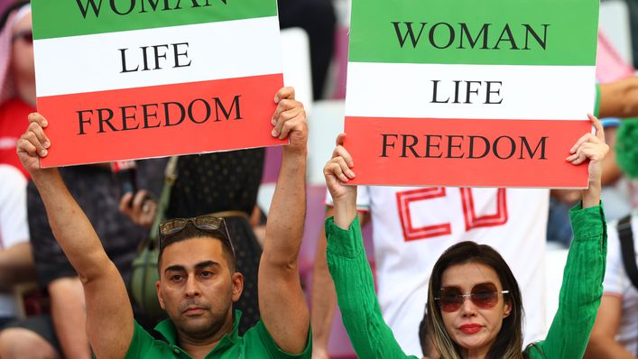 Iranian fans hold up signs in support of women's rights during the match against England